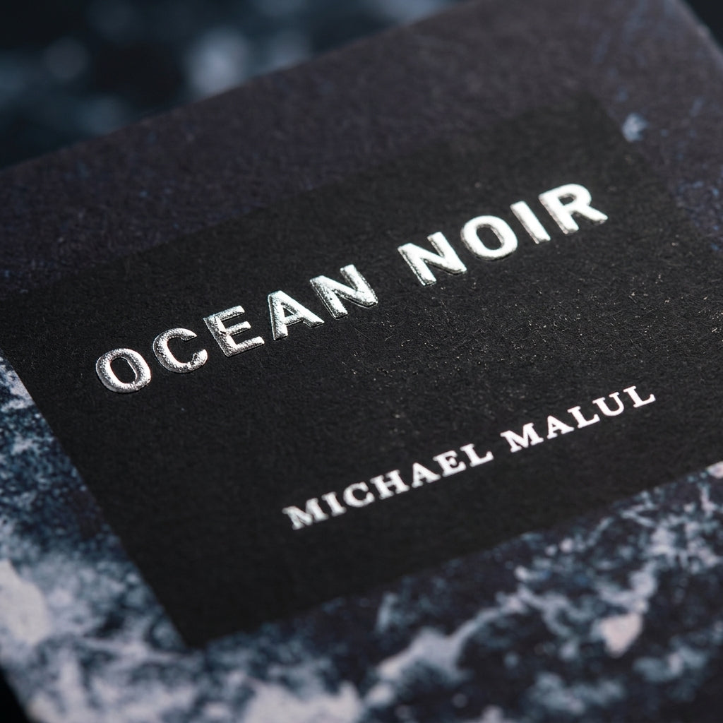 Close-up of Michael Malul Ocean Noir embossed carton texture and typography